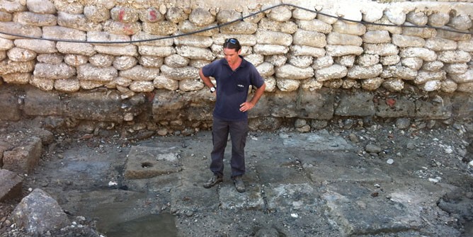 A member of the Israel Antiquities Authority standing on the ancient quay in Acre. (Photo: Kobi Sharvit/IAA)