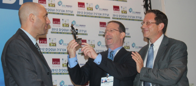 Shaul Tzemach, Director General of the Ministry of Energy and Water, looks on as Dr. Amit Mor, Co-CEO of Eco Energy, presents Yosef Abramowitz, President of Arava Power Company, the 2012 Energy and Business Convention Person of the Year Award. (Hannah Schafer)