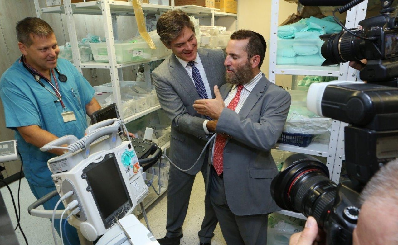 Dr. Shlomi Israelit, director of Rambam’s emergency trauma department, shows Rabbi Shmuley Boteach and Dr. Mehmet Oz some of the hospital's scanning devices. (Pioter Fliter)