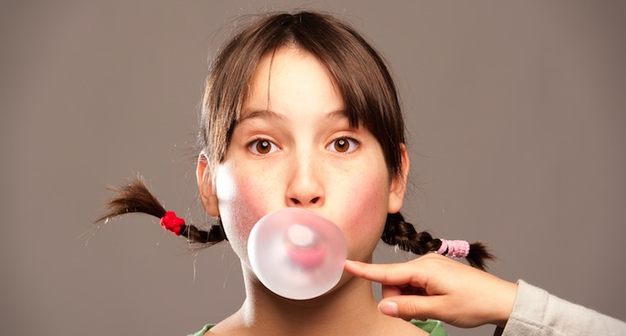 Pop that gum-chewing habit to lessen headaches. Image via Shutterstock.com
