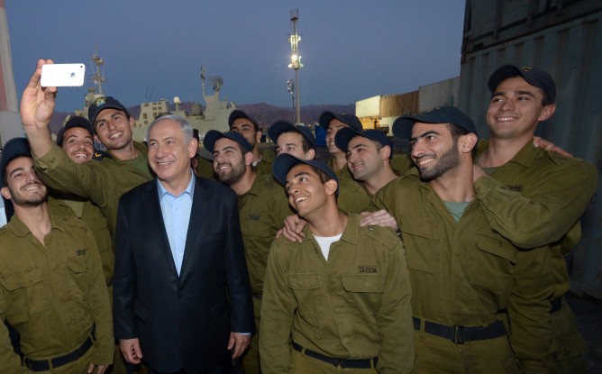 Prime Minister Benjamin Netanyahu poses for a selfie with IDF soldiers.   (Haim Zach/ GPO/Flash90)