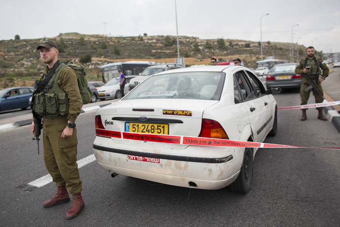IDF soldiers stand guard at the scene of a terror attack on December 12, 2014. (Photo by Yonatan Sindel/Flash90)