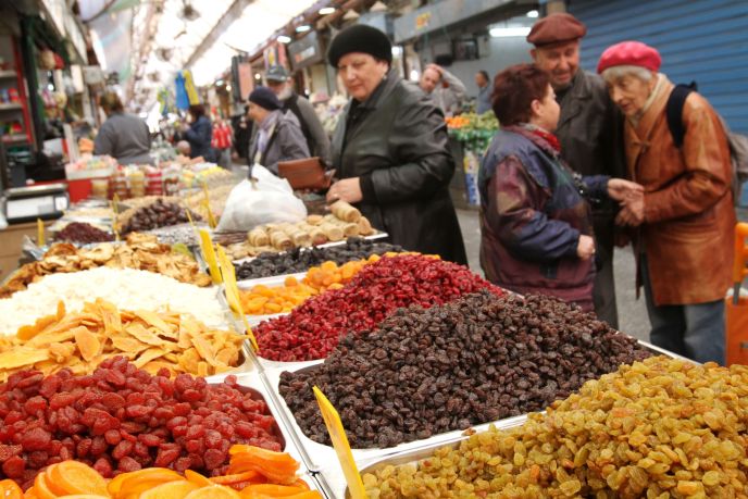 Customers choosing dried fruits for sale at the Machane Yehuda market in Jerusalem in preparation for the Jewish holiday of Tu B’Shevat. Photo by Miriam Alster/FLASH90