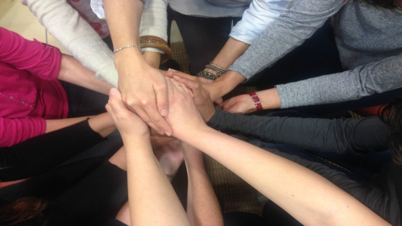 A group of autism professionals link hands during resiliency training. Photo courtesy of ACR