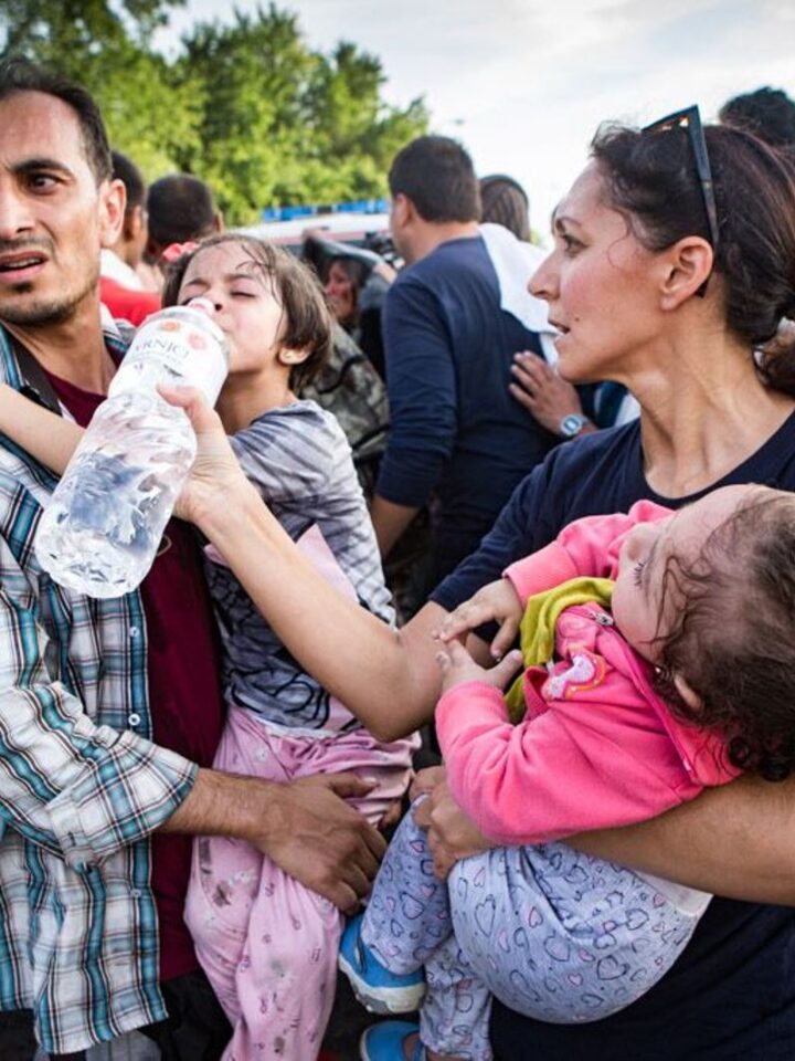 IsraAID volunteer Rachel Lasry Zahavi helping a father care for his daughters during the Hungarian border riot. Photo by Mickey Noam Alon/IsraAID