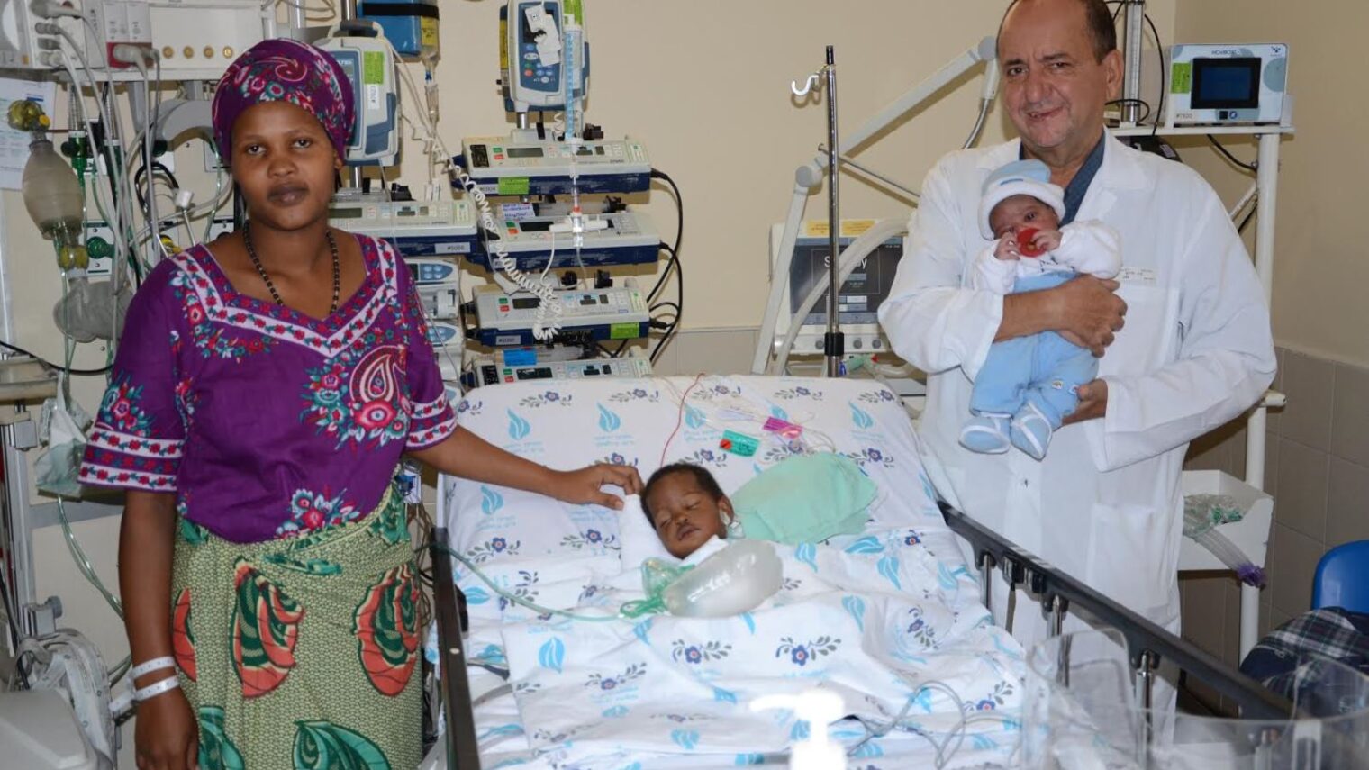 Elieth from Tanzania visiting her daughter Dorice in the Wolfson PICU as Dr. Sion Houri holds newborn Laura. Photo by Barak Nuna