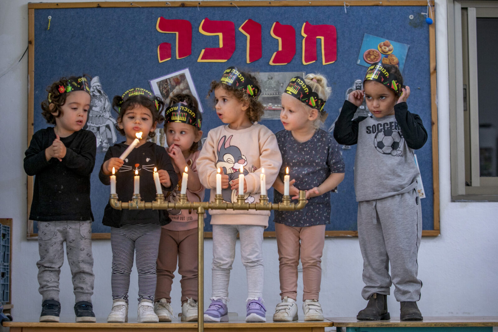 Children light Hanukkah candles at a kindergarden in Moshav Yashresh, on November 25, 2021. Photo by Yossi Aloni/Flash90