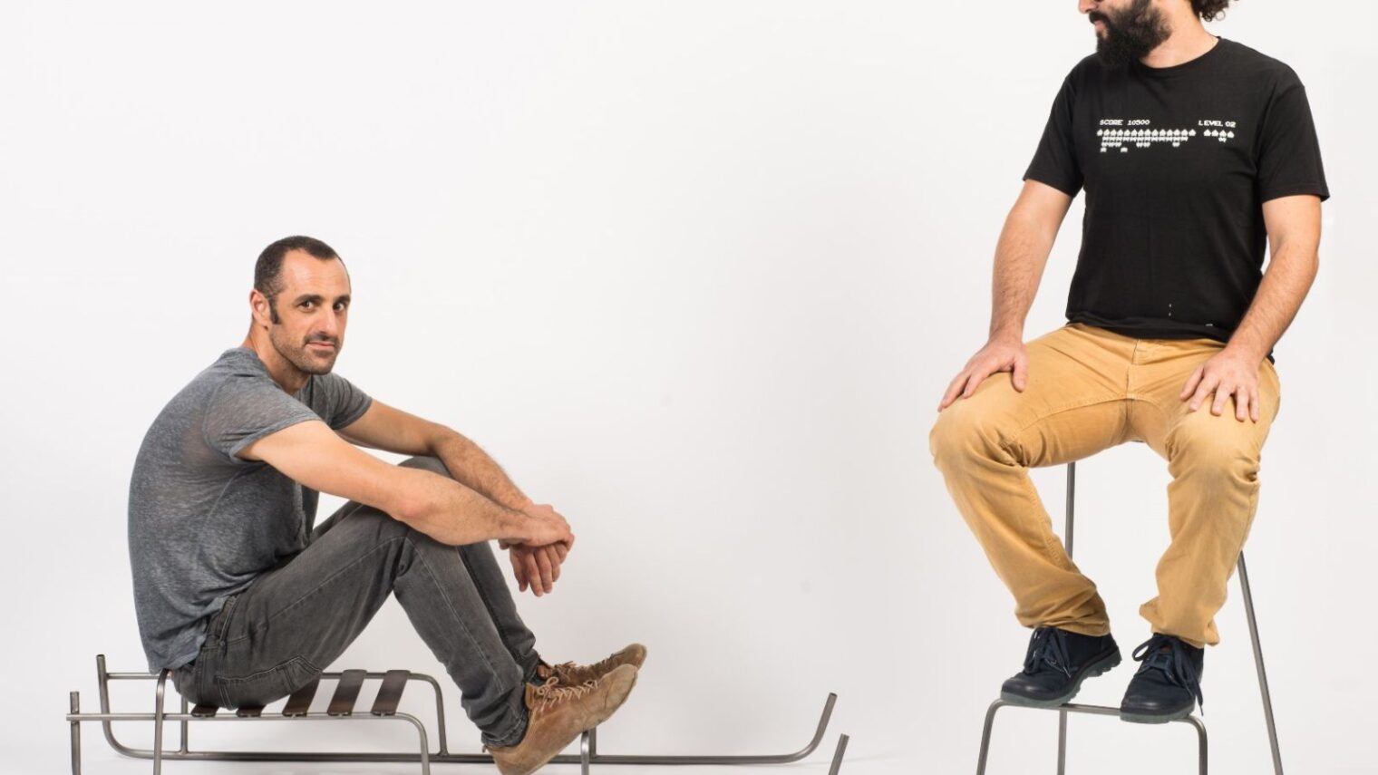 Neil Nenner, left, and Lior Yamin of SAGA TLV gallery in Jaffa trying out Nennerâ€™s minimalist seating designs. Photo by Shachar Fleischmann