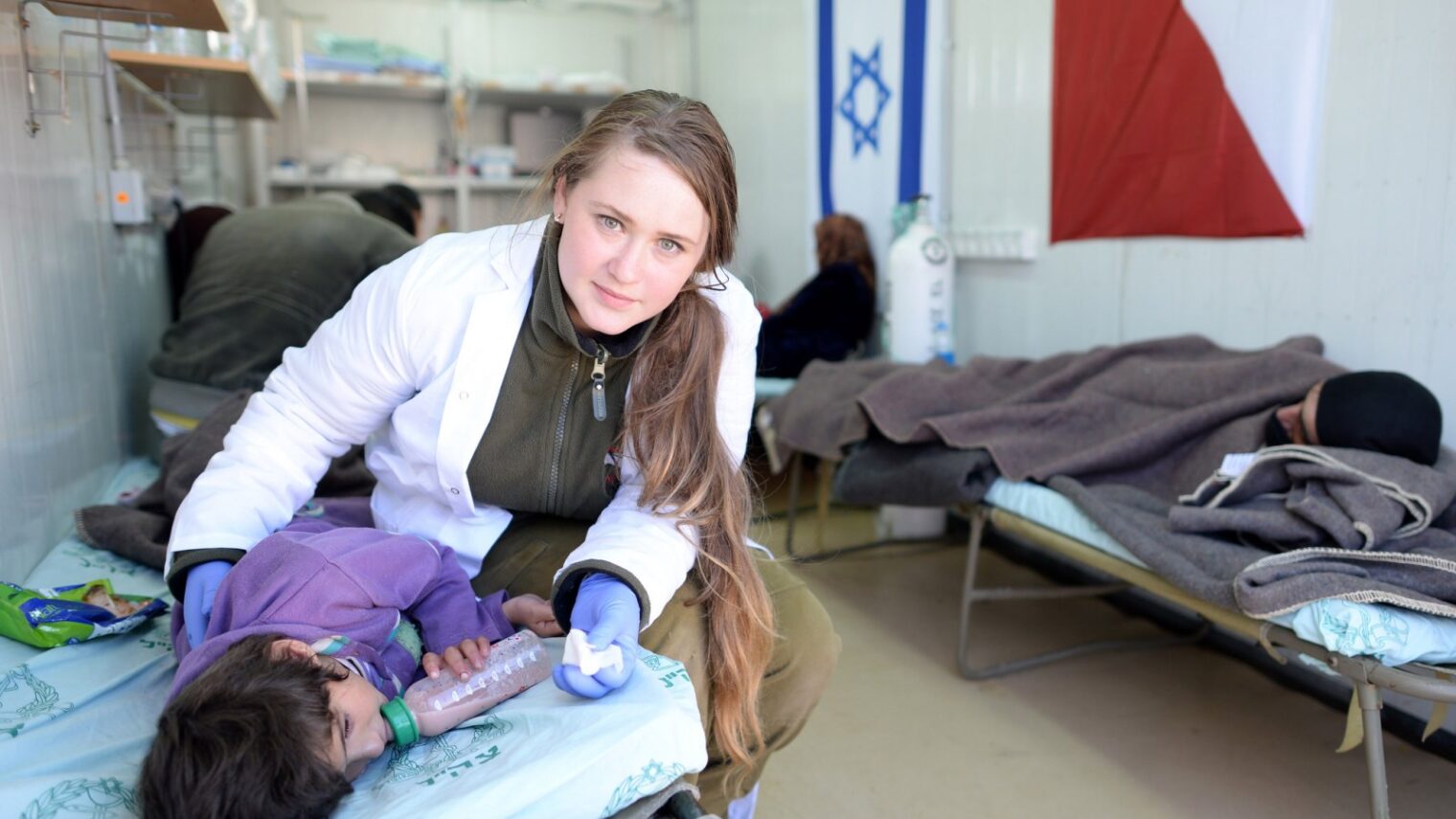 An IDF medic treats an injured Syrian girl at a field hospital in northern Israel. Photo by GPO