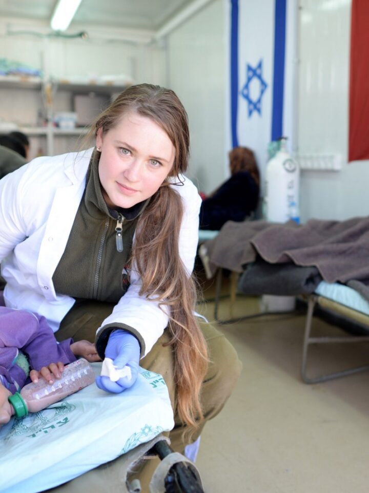 An IDF medic treats an injured Syrian girl at a field hospital in northern Israel. Photo by GPO