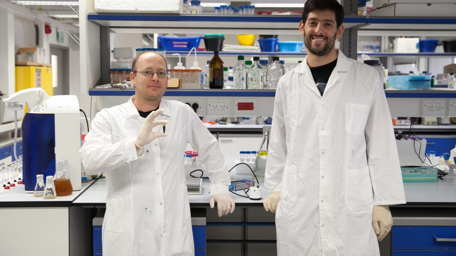 Doctoral students Dan Kallmann, left and Gadiel Saper with spinach extract in the Technion Hydrogen Lab. Photo: courtesy