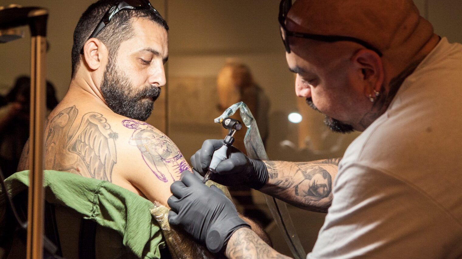 Steve Soto tattoos Barak Miron in the Archeology Wing of the Israel Museum. Photo: courtesy