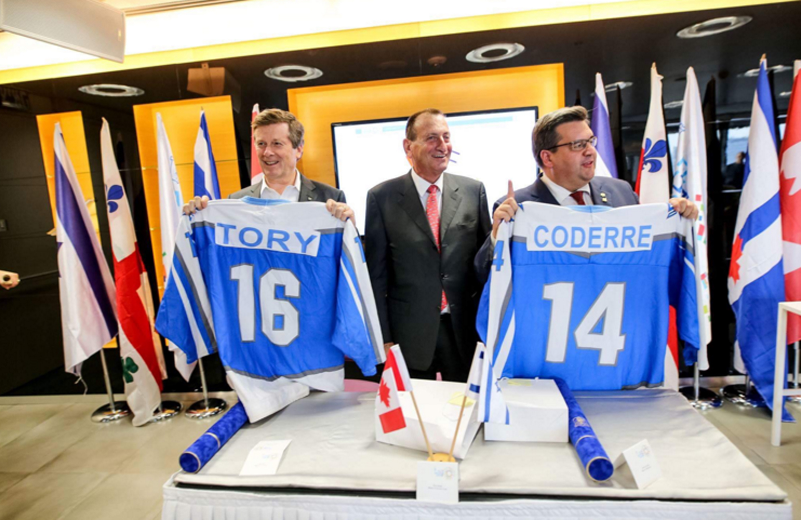 Tel Aviv Mayor Ron Huldai gives Israeli hockey jerseys to Mayor of Montréal Denis Coderre and Mayor of Toronto John Tory in welcoming them to Israel. Photo via twitter.com/MayorOfTelAviv