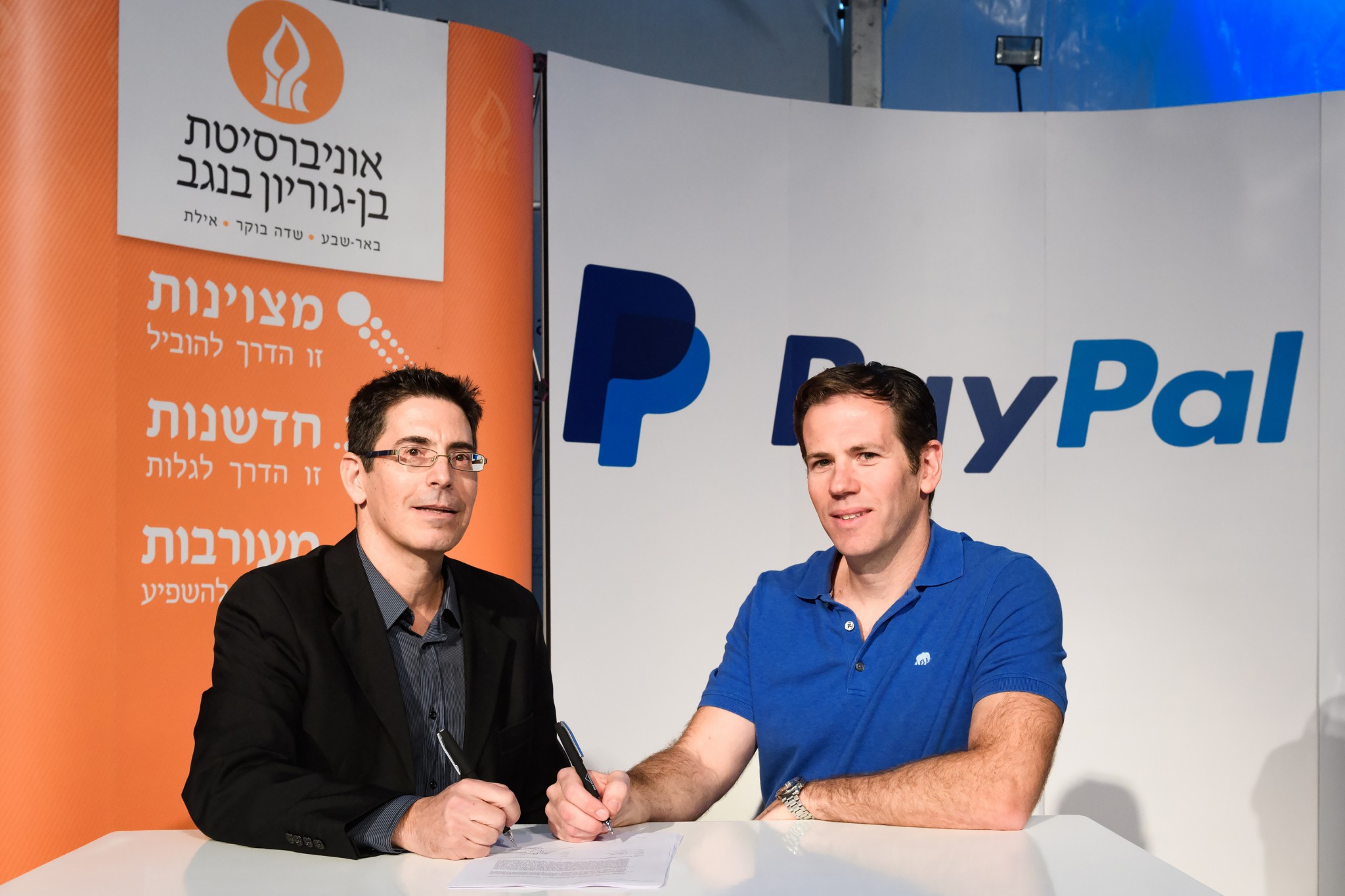 Netta Cohen, BGN Technologies CEO (left), and Matan Parnes, PayPal's General Manager in Israel, sign the agreement at the Nextech Conference at the Gav Yam Negev Advanced Technologies Park in Beersheva. Photo by Dani Machlis/BGU