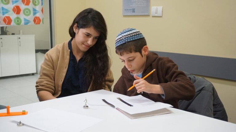 Ido trying out the adapted ruler for the first time with Hila Moore. Photo courtesy of TOM:Tikkun Olam Makers