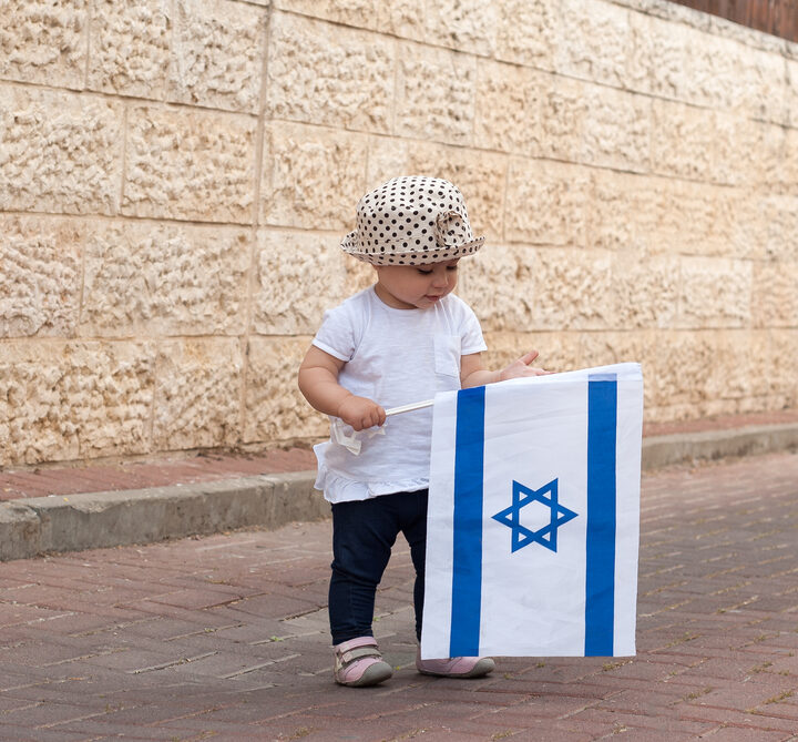 Child holds Israeli flag. Photo by Shutterstock.com
