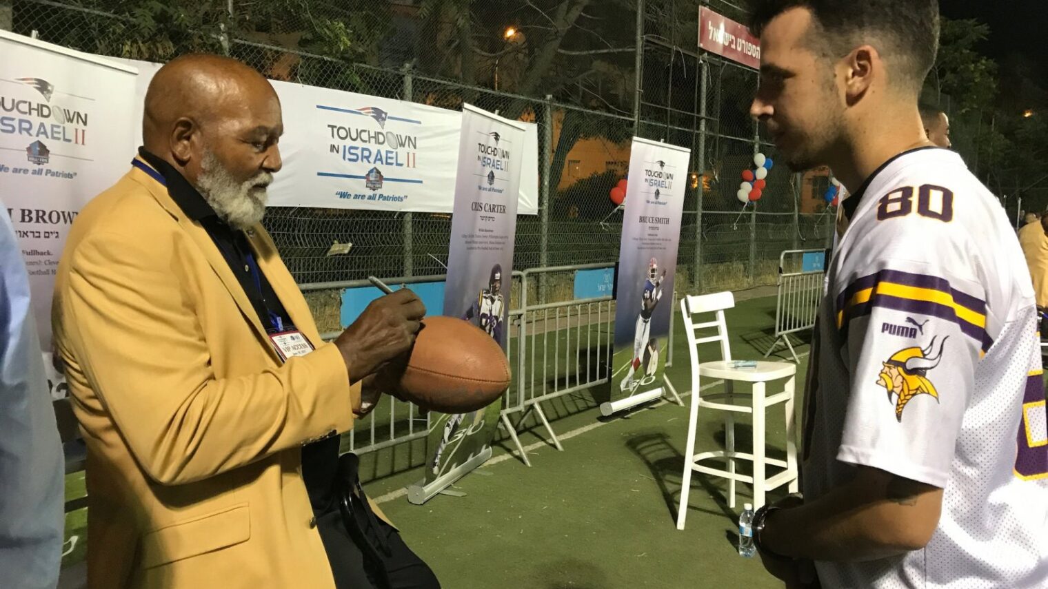 Former Cleveland Browns great Jim Brown signing a football for a fan at Kraft Family Stadium, Jerusalem, June 18, 2017. Photo by Abigail K. Leichman