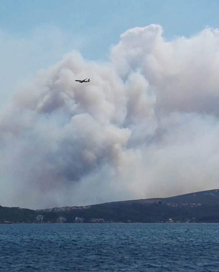 A plane flies over smoke from fires in Montenegro. Photo by Marina Constantinoiu