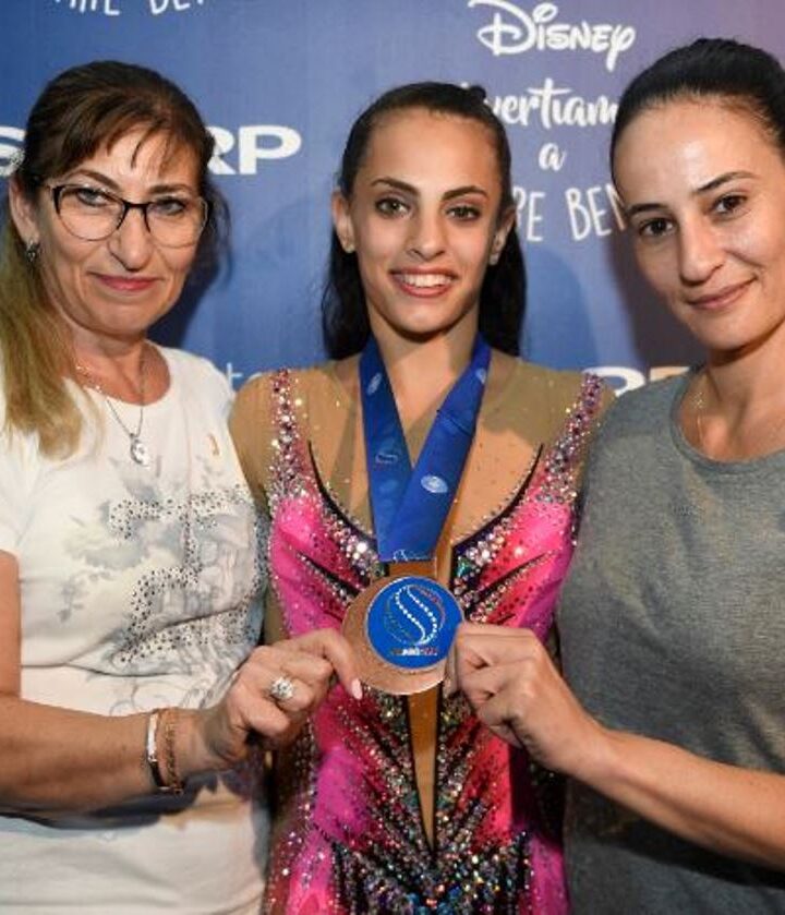 Linoy Ashram flanked by her coaches after winning a bronze medal in the 2017 World Rhythmic Gymnastics Championships in Italy, September 1, 2017. Photo by Amit Shisel