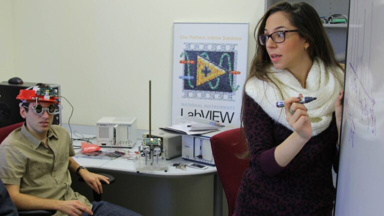 Dr. Oz Levinkron, seated, of the Technion Faculty of Medicine, wears the device that can diagnose diseases based on eyelid motion. At right, lead researcher Adi Hanuka of the Technion. Photo: courtesy