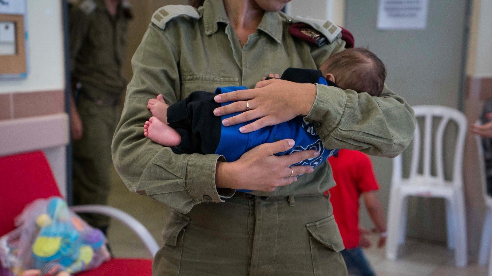 An Israeli soldier cradling a child at the Israeli field hospital near the Syrian border. Photo courtesy of IDF Spokesman’s Office