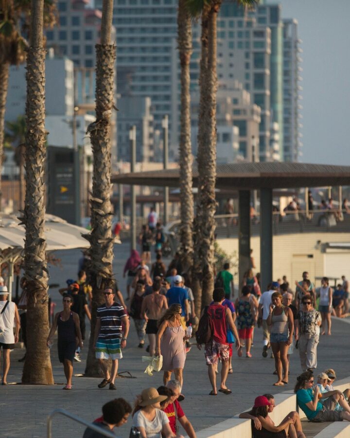 Israelis and tourists walk on the promenade by the beach in Tel Aviv. Photo by Miriam Alster/FLASH90