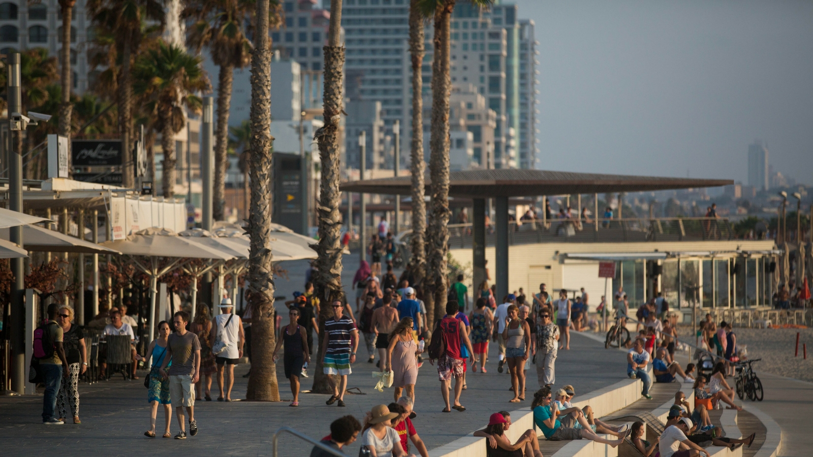 Israelis and tourists walk on the promenade by the beach in Tel Aviv. Photo by Miriam Alster/FLASH90