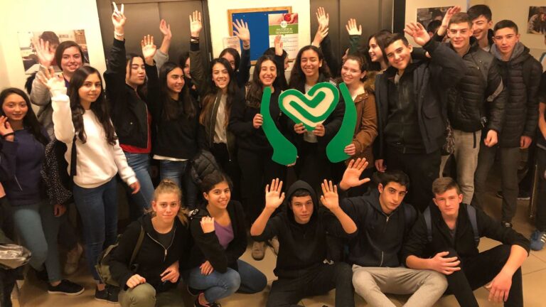 Ninth-graders from Modii’n pose with the Tikkun Olam logo during a visit to ALEH Jerusalem. Photo courtesy of ALEH