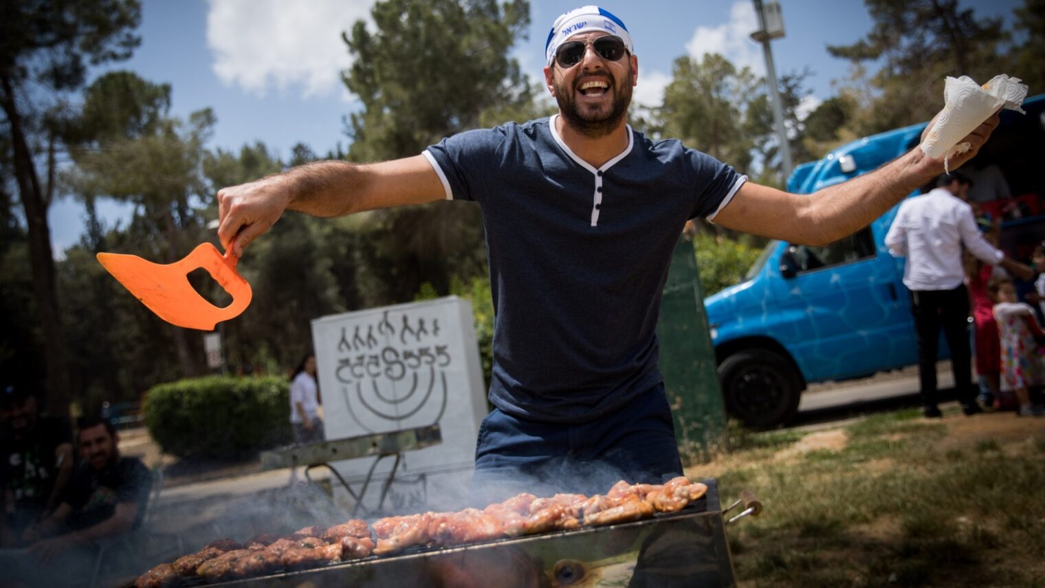 An Israeli grill master wields his nafnaf at an Independence Day cookout. Photo by Yonatan Sindel/FLASH90