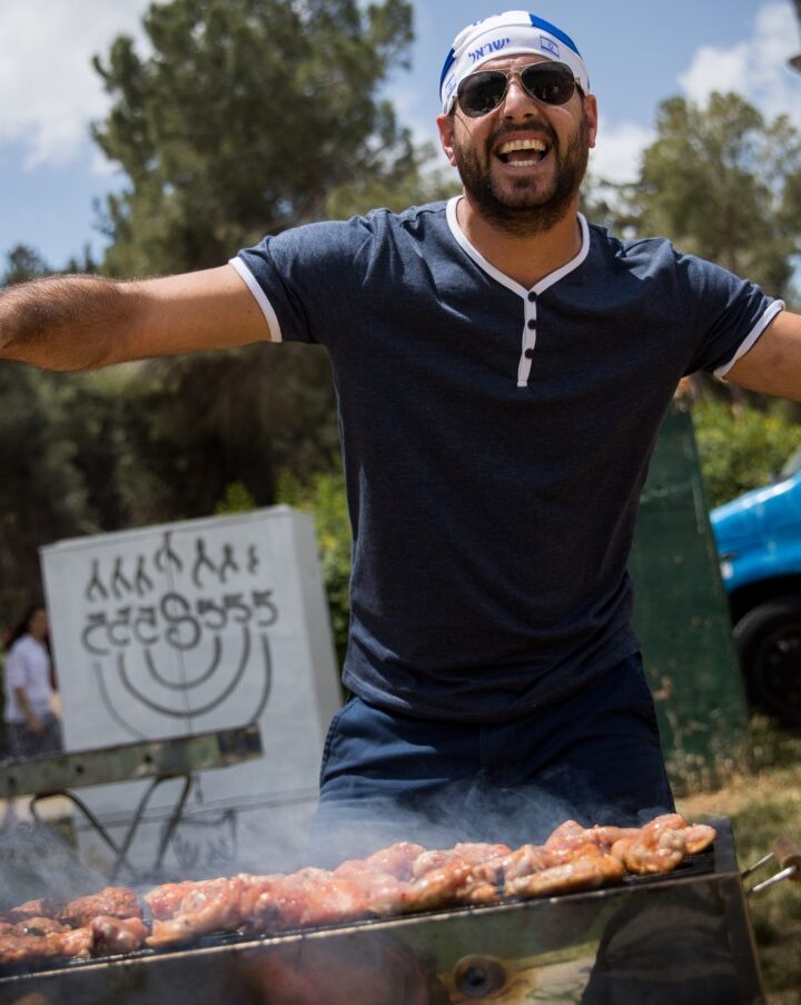 An Israeli grill master wields his nafnaf at an Independence Day cookout. Photo by Yonatan Sindel/FLASH90