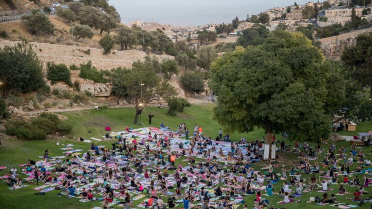 Participants attend a mass yoga class in Jerusalem, on International Yoga Day, using specially designed yoga mats that collectively form an artwork envisioning the future of Jerusalem. Photo by Yonatan Sindel/FLASH90