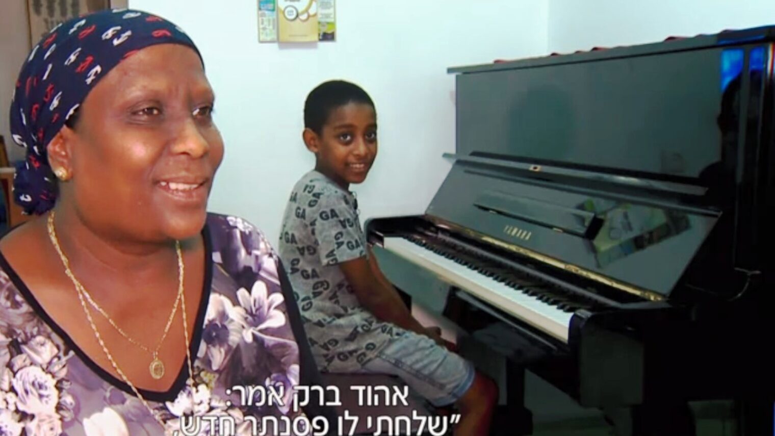 The subtitle on this screenshot of Oshri Bitau and his mother translates as, “Ehud Barak said, ‘I’m sending him a new piano.’”