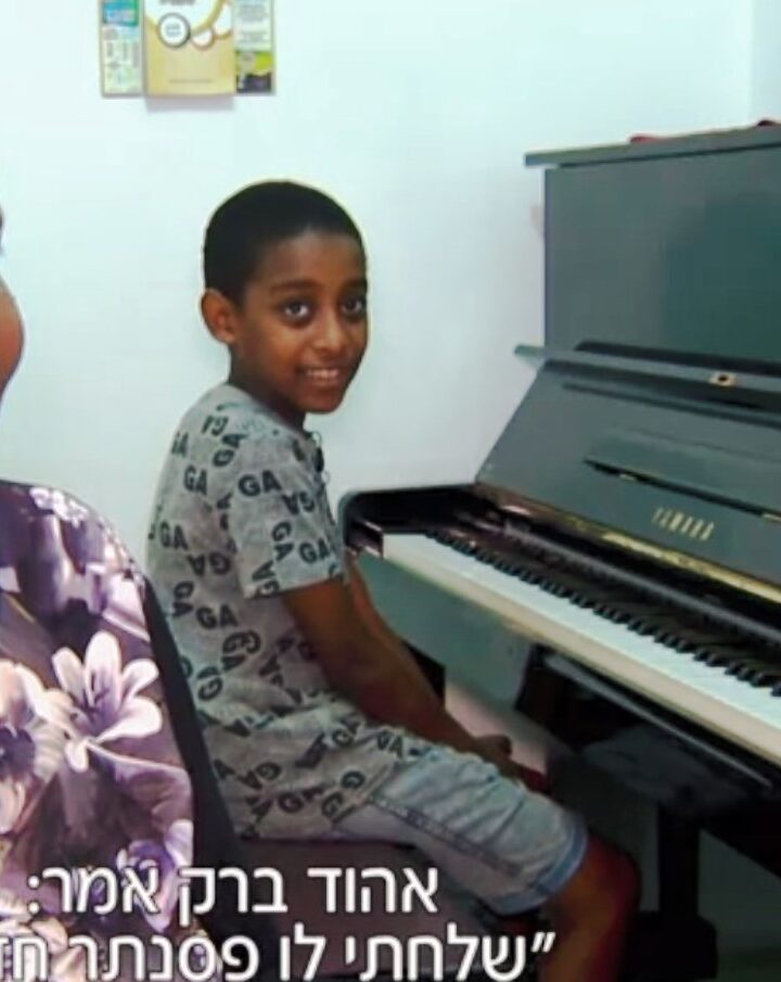 The subtitle on this screenshot of Oshri Bitau and his mother translates as, â€œEhud Barak said, â€˜Iâ€™m sending him a new piano.â€™â€�