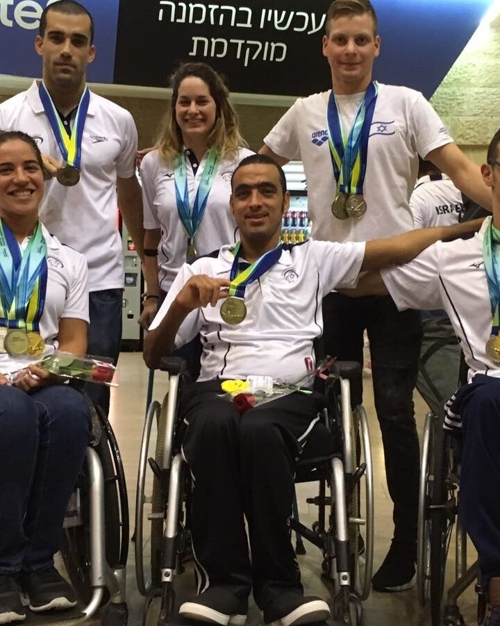 Medal-winning Paralympic swimmers back in Israel on August 20, 2018, from left (seated), Ami Dadon, Iyad Shalabi and Inbal Pezaro; (standing) Mark Malyar, Erel Halevi and Yoav Valinsky. Photo courtesy of Israel Paralympics Committee
