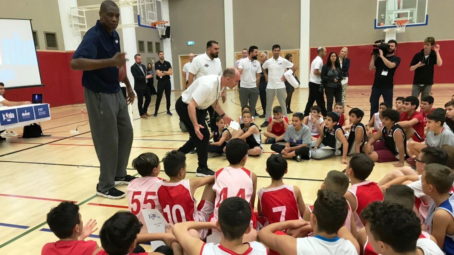 Basketball Hall of Famer Dikembe Mutombo and an NBA official greeting kids in the new Jr. NBA Jerusalem International YMCA League. Photo by Abigail Klein Leichman