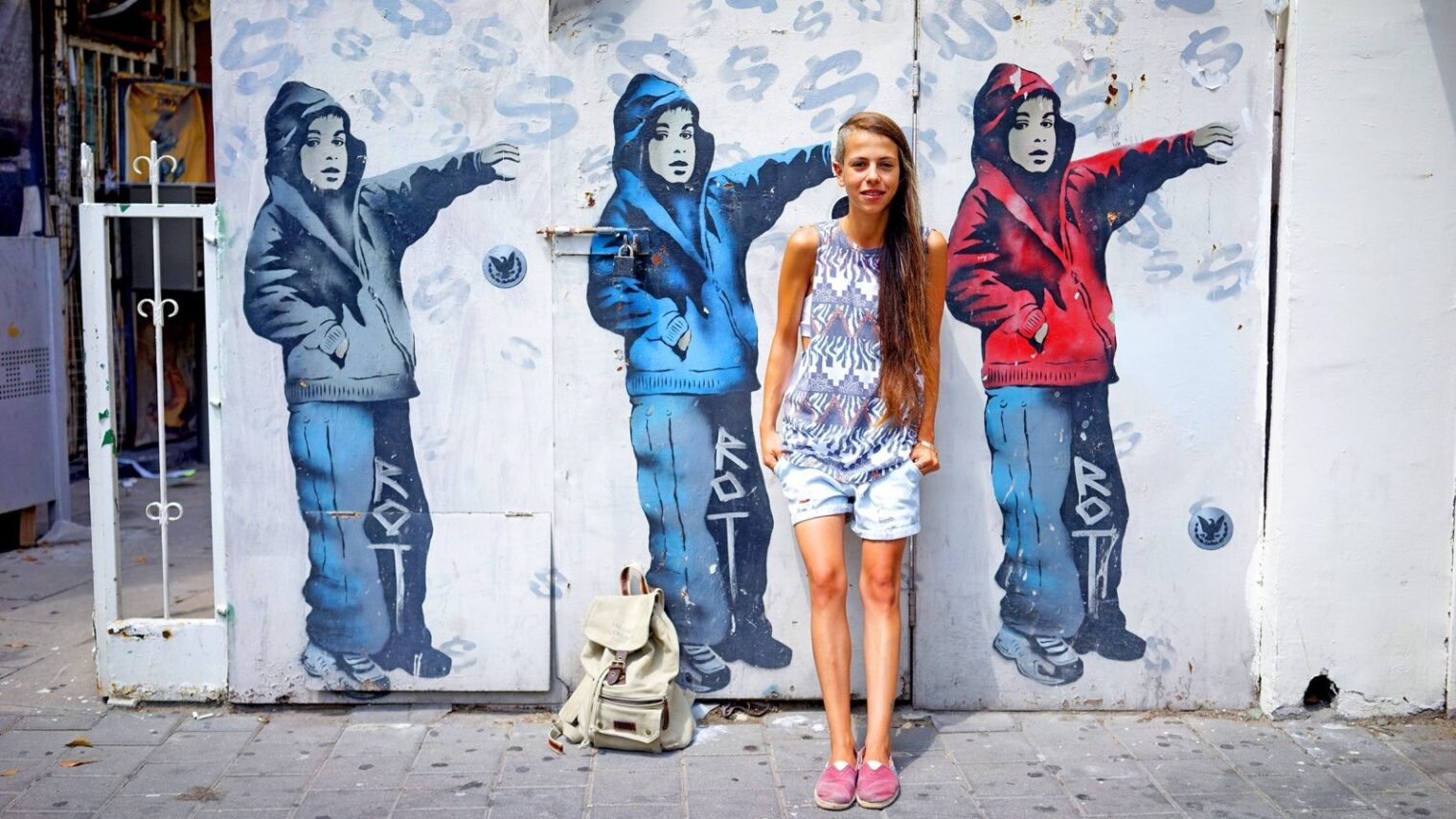A passerby blends in with street art in Tel Aviv. Photo by Ido Biran