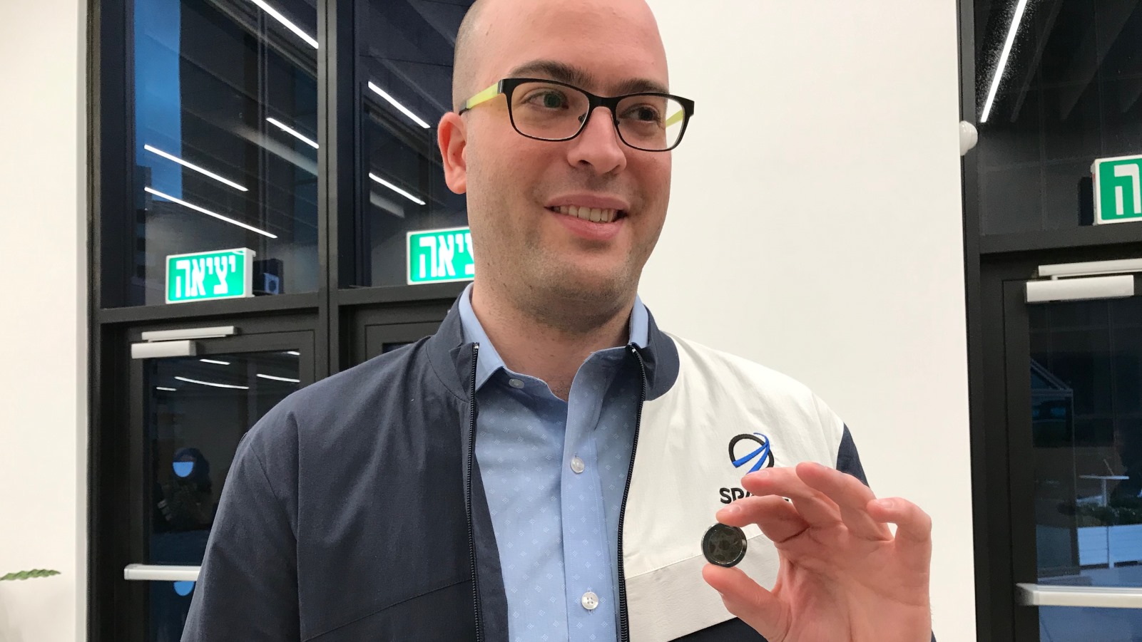 SpaceIL cofounder Yonatan Winetraub displaying a copy of the coin-size nano Bible in the time capsule aboard Beresheet. Photo by Abigail Klein Leichman