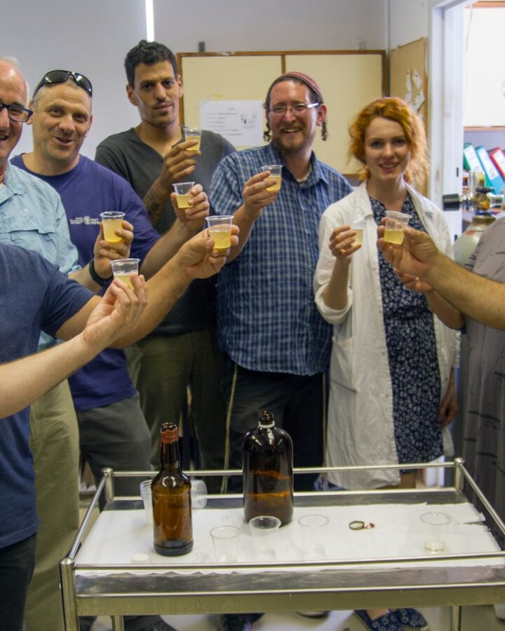 The team of Israeli researchers with new-old beer produced from ancient yeast. Photo by Yaniv Berman/Israel Antiquities Authority
