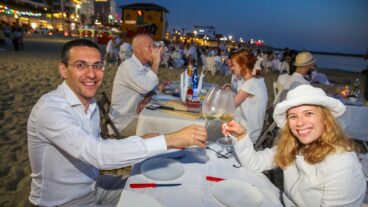 People dressed in white attend the Tel Aviv White Dinner, during the opening of the Tel Aviv White Night Festival, at the beach in Tel Aviv on May 15, 2019. Photo by Flash90