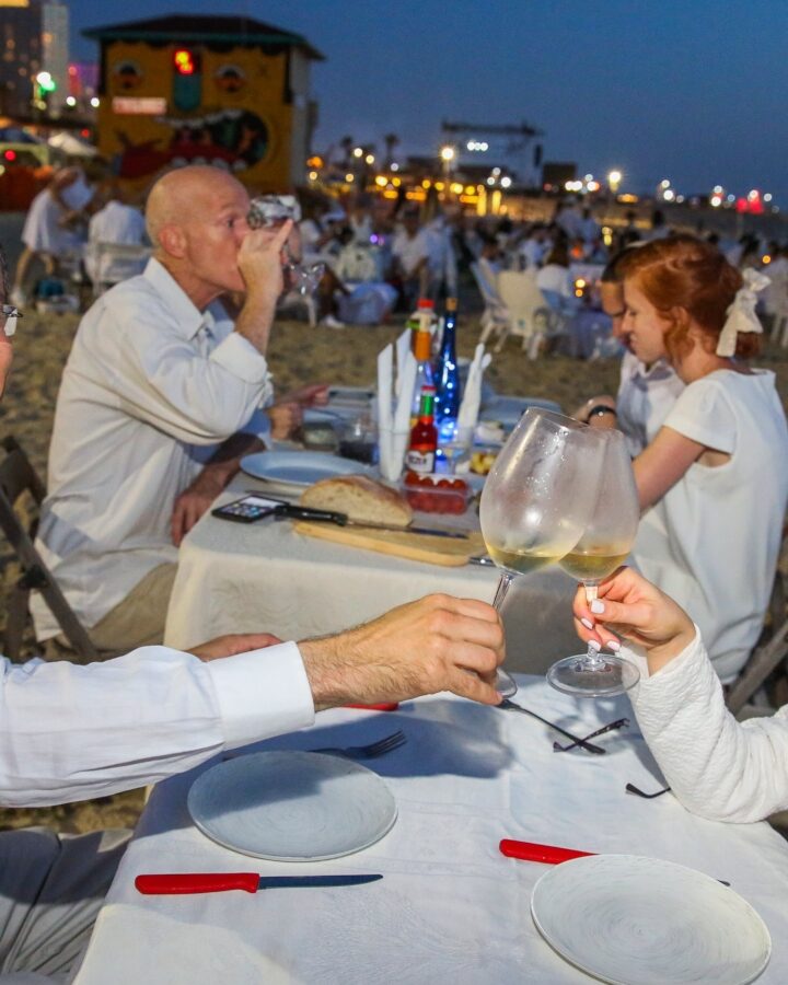 People dressed in white attend the Tel Aviv White Dinner, during the opening of the Tel Aviv White Night Festival, at the beach in Tel Aviv on May 15, 2019. Photo by Flash90