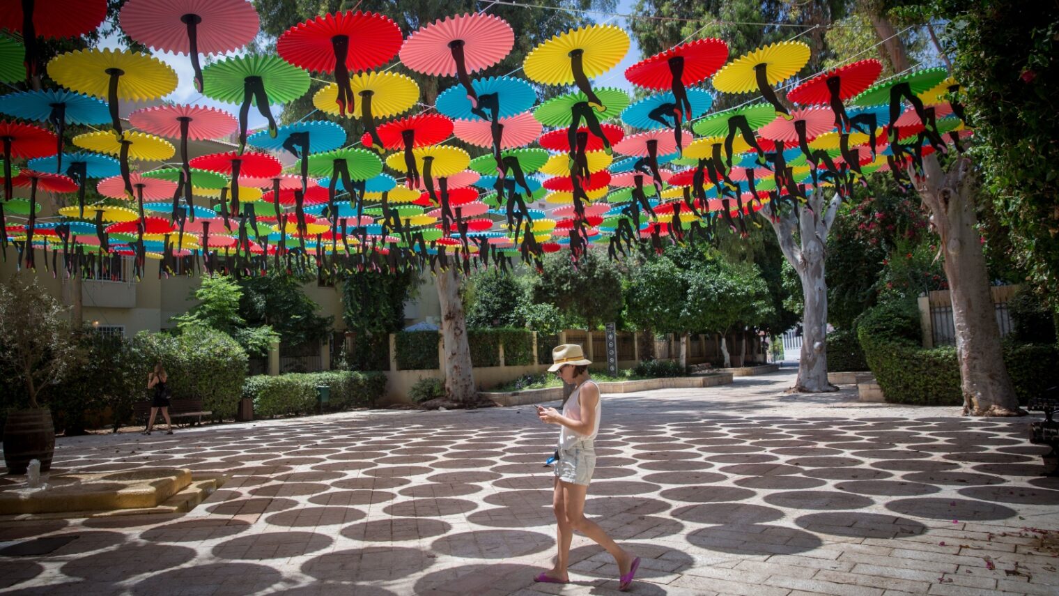 Wear light-colored, lightweight clothing and a hat, and find yourself some shade in the Israeli summer. This photo was taken outside the Suzanne Dellal Center in Tel Aviv. Photo by Miriam Alster/FLASH90