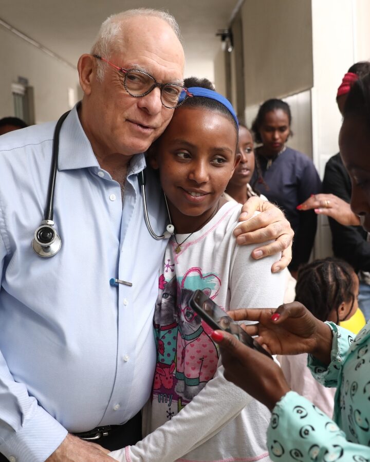 Save a Child’s Heart cofounder Dr. Akiva Tamir hugging a past patient. Photo by Yonatan Sindel