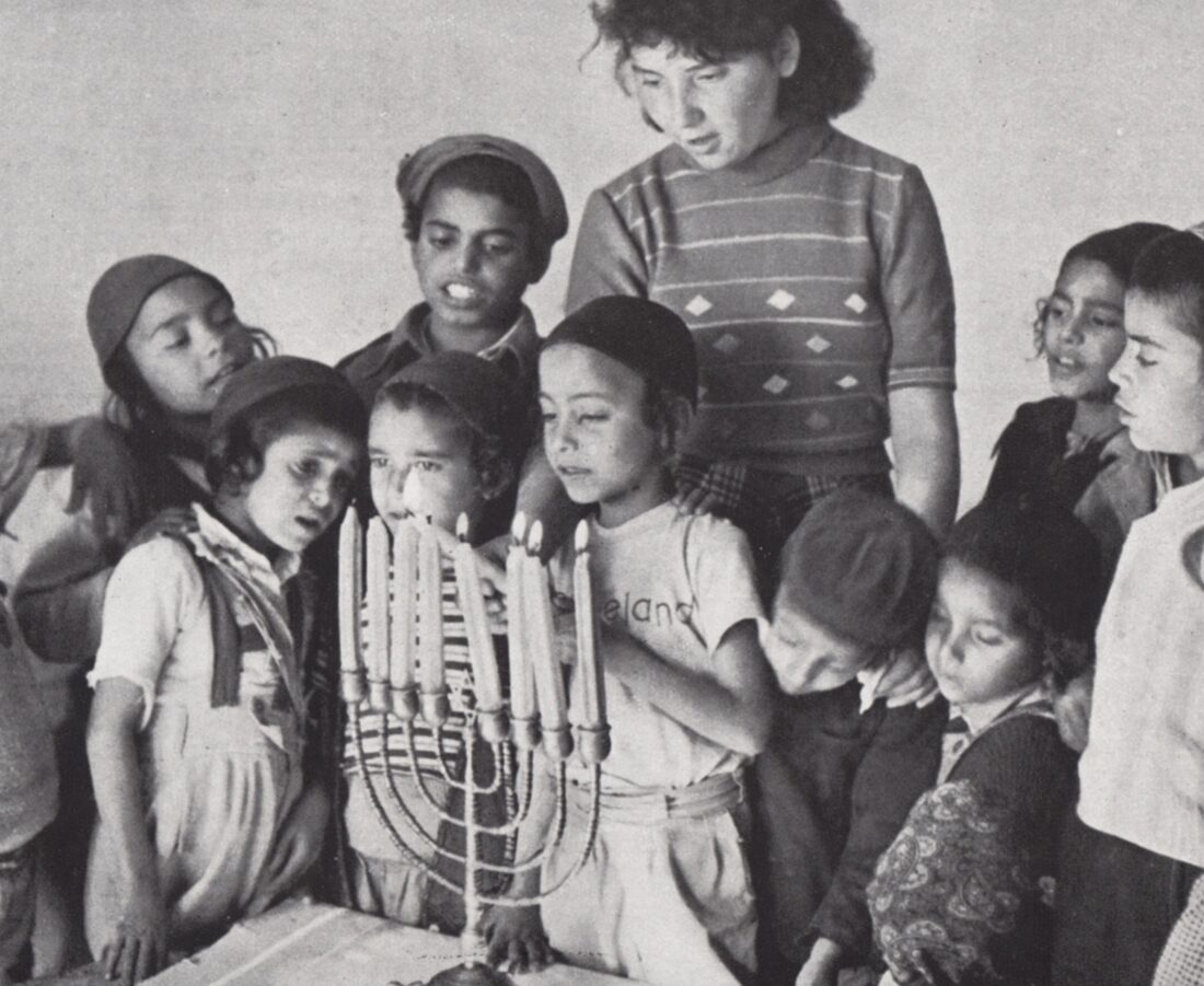 Schoolchildren light Hanukkah candles at a 1950s maabara immigrant camp. Photo: PikiWiki Israel