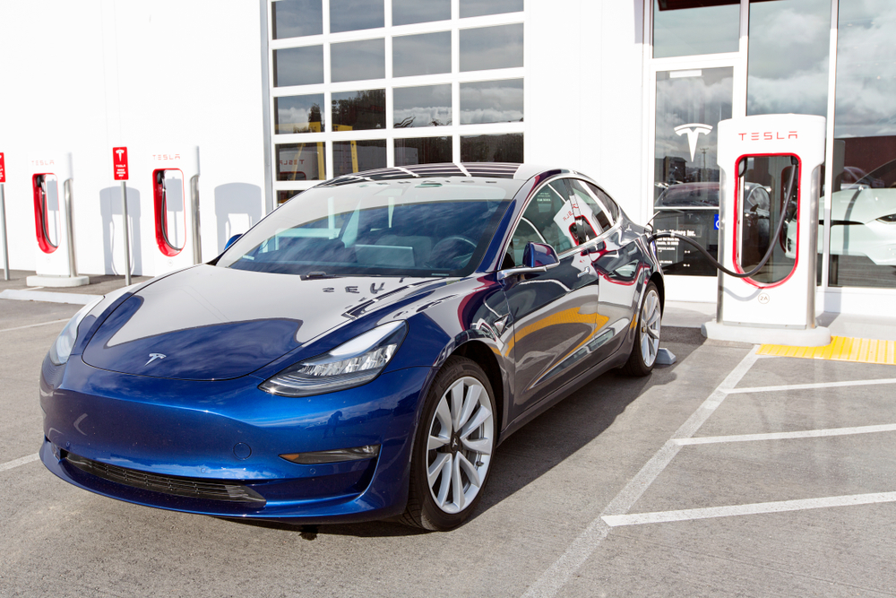 A Tesla Model 3 at a Supercharger station. Photo by Aleksei Potov via Shutterstock.com