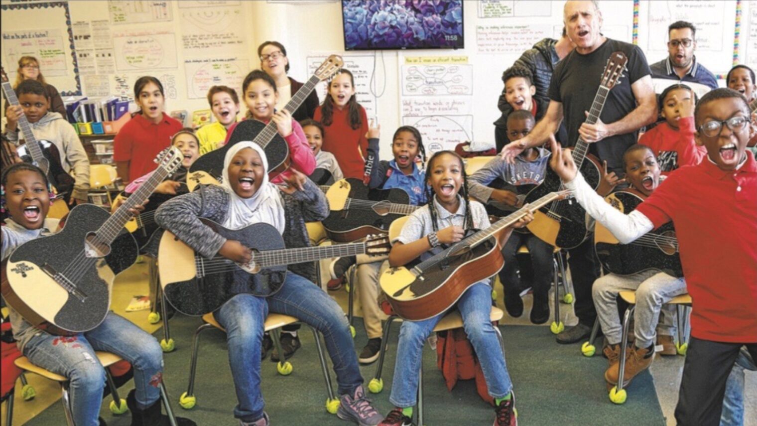 David Broza giving guitars to pupils in a charter school in the Bronx, New York. Photo courtesy of One Million Guitars