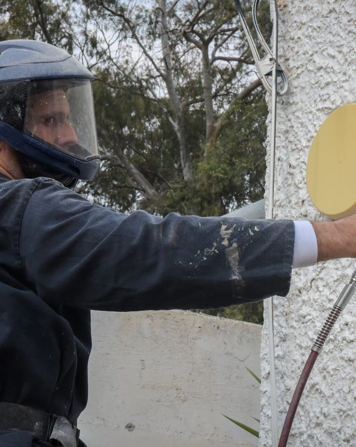 A man wearing protective gear works outside a building at the Sheba Medical center that was converted to receive the Israelis coming in from quarantine in Japan. (Avshalom Shoshani/Flash90)