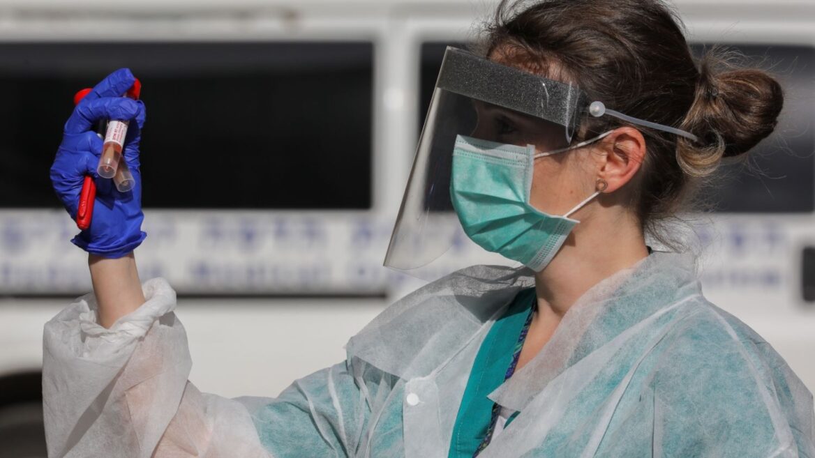 A worker at Hadassah Medical Center in Jerusalem handling coronavirus test samples. Photo by Olivier Fitoussi/Flash90