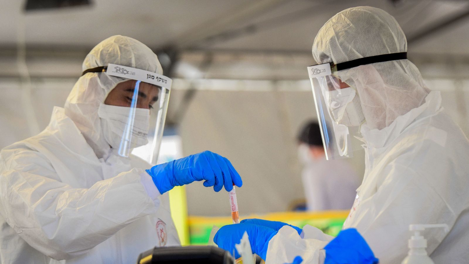 Medical personnel handle a coronavirus test sample in Tel Aviv. Photo by Flash90
