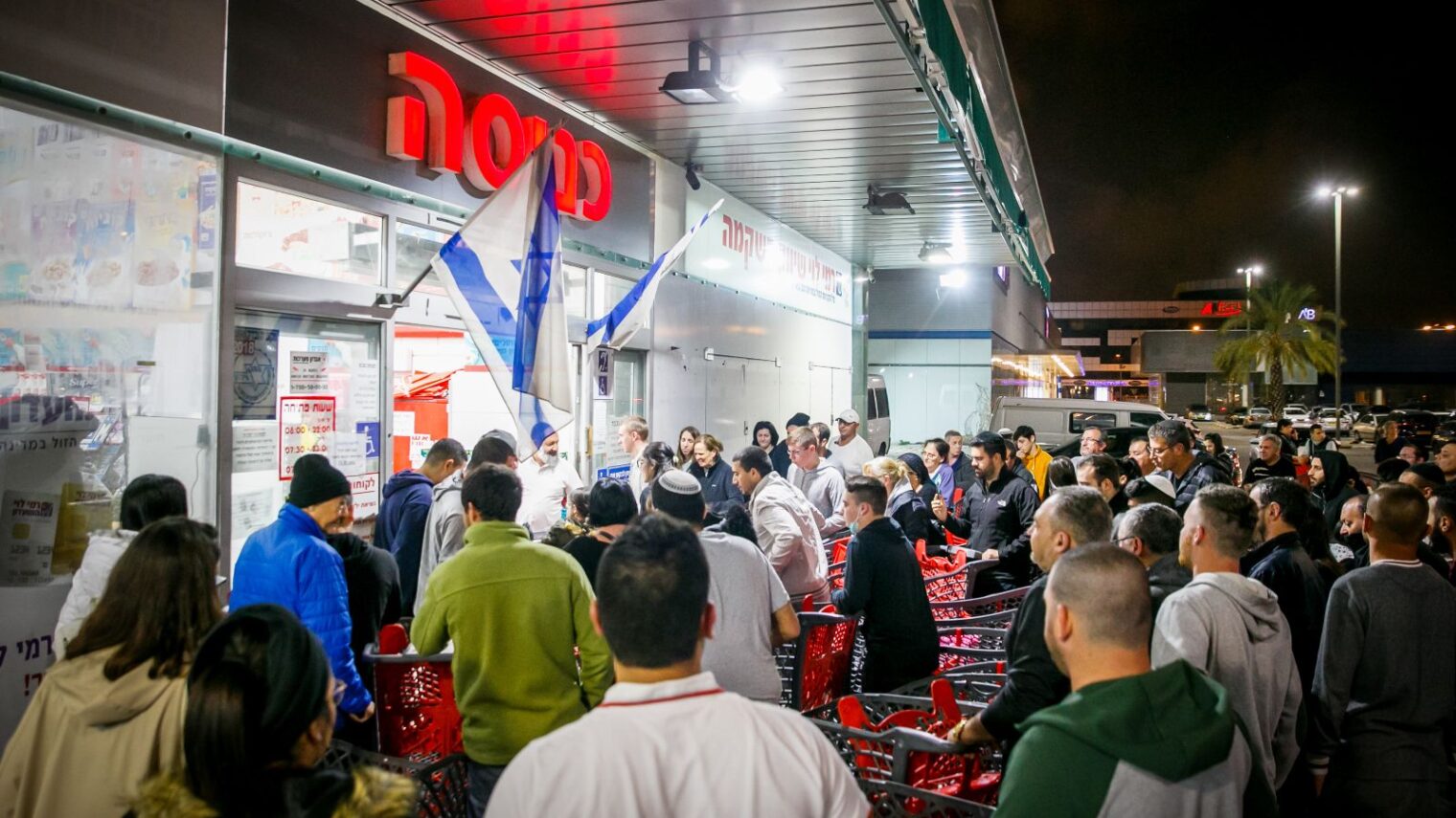 People line up outside a supermarket in Ashdod. Photo by Flash90