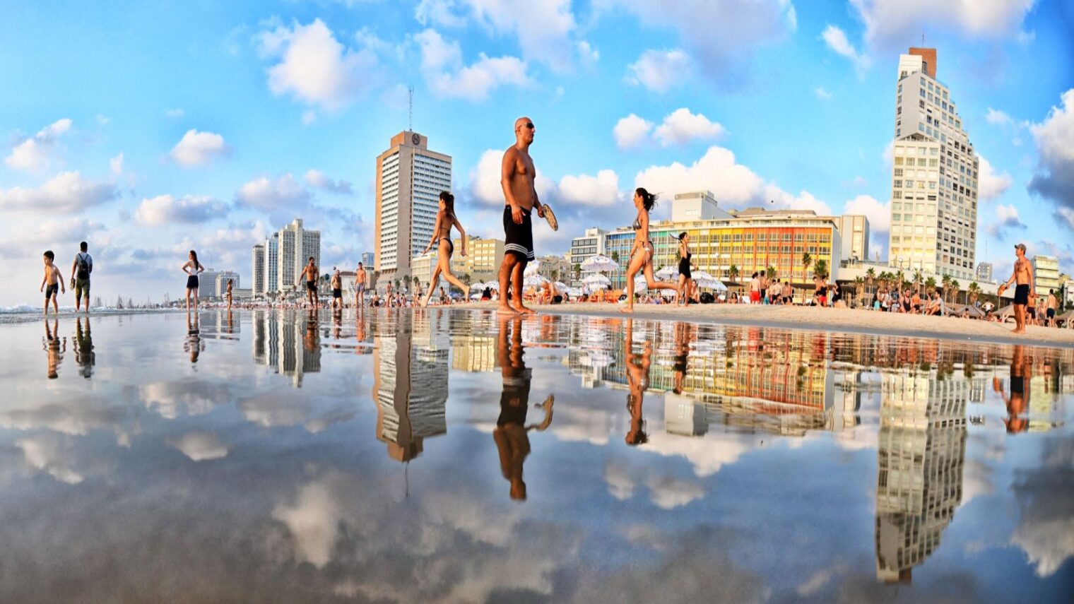 Beach goers play matkot against the backdrop of Tel Aviv's shoreline. Photo by Amir Chodorov